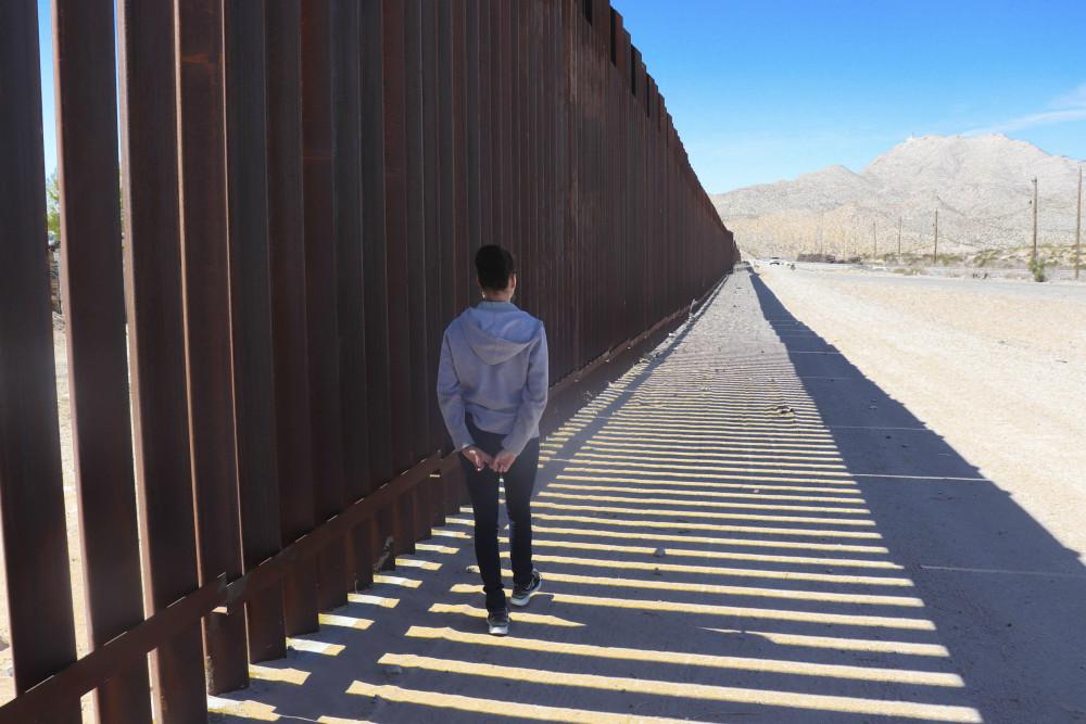 A 十大菠菜台子 student walks a segment of the border wall between the United States and Mexico.